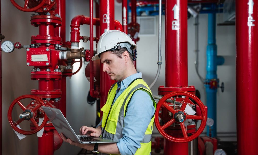 Engineers inspecting the inside plumbing and water valves of an industrial facility.